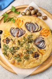 Photo of Delicious focaccia with flowers made of vegetables on grey table, top view