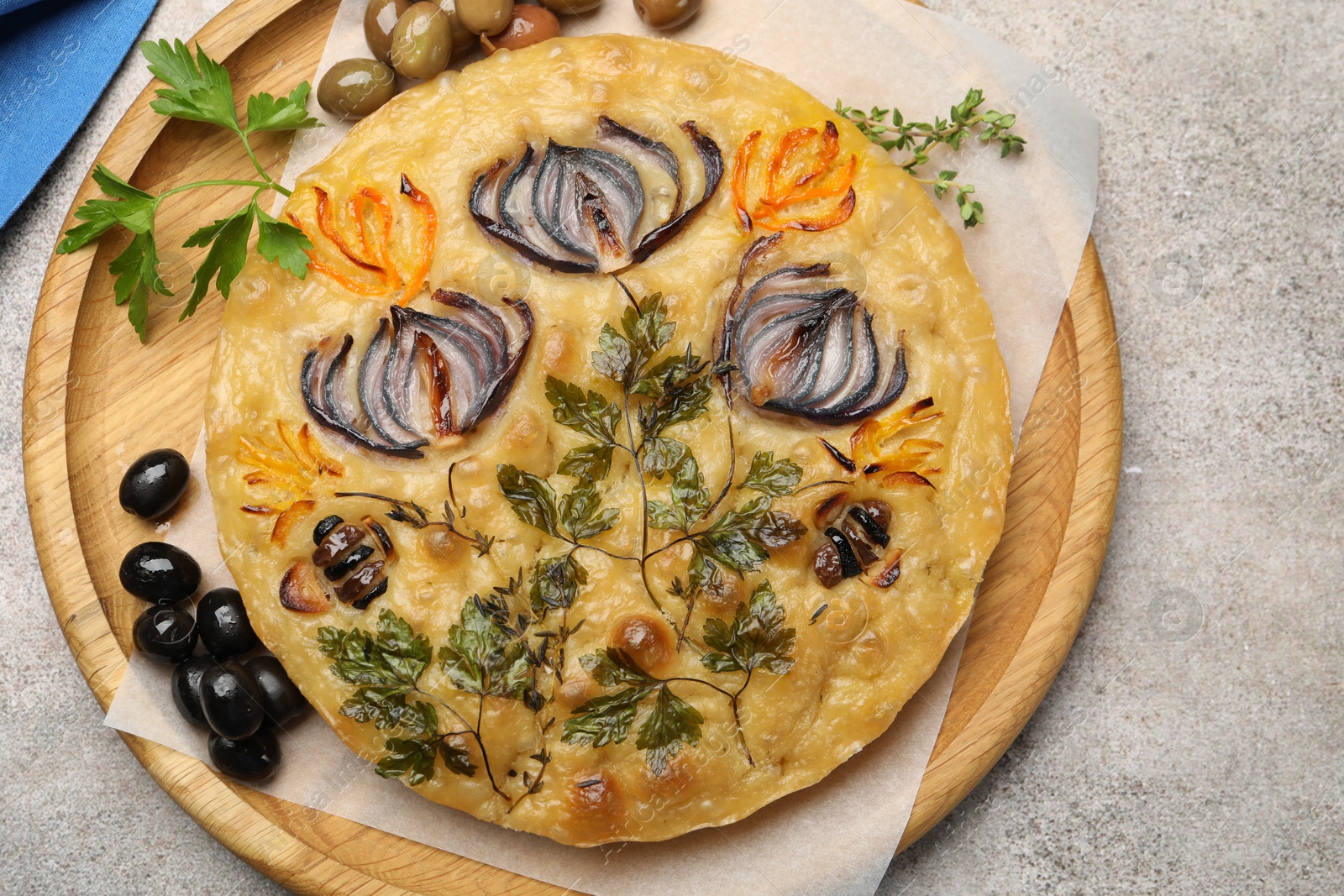 Delicious focaccia with flowers made of vegetables on grey table, top view Photo of Delicious focaccia with flowers made of vegetables on grey table, top view