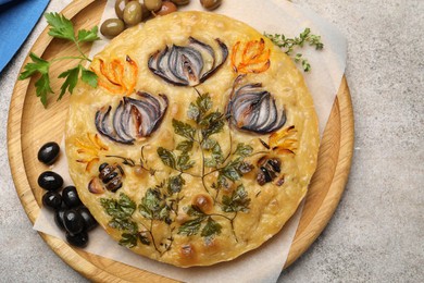 Photo of Delicious focaccia with flowers made of vegetables on grey table, top view