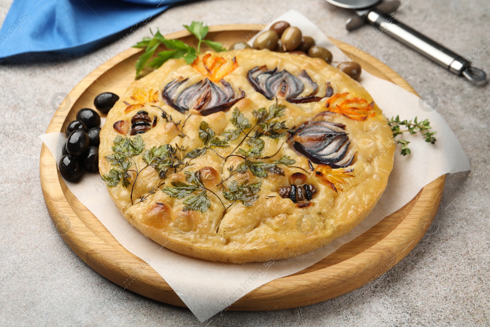 Delicious focaccia with flowers made of vegetables and cutter on grey table, closeup Photo of Delicious focaccia with flowers made of vegetables and cutter on grey table, closeup