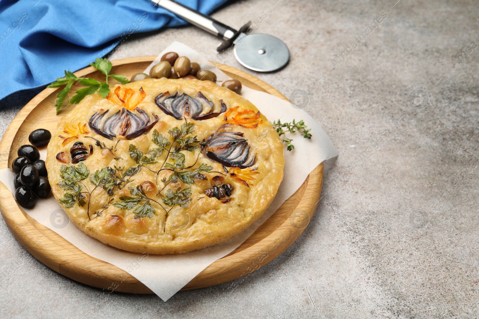 Delicious focaccia with flowers made of vegetables and cutter on grey table, closeup. Space for text Photo of Delicious focaccia with flowers made of vegetables and cutter on grey table, closeup. Space for text
