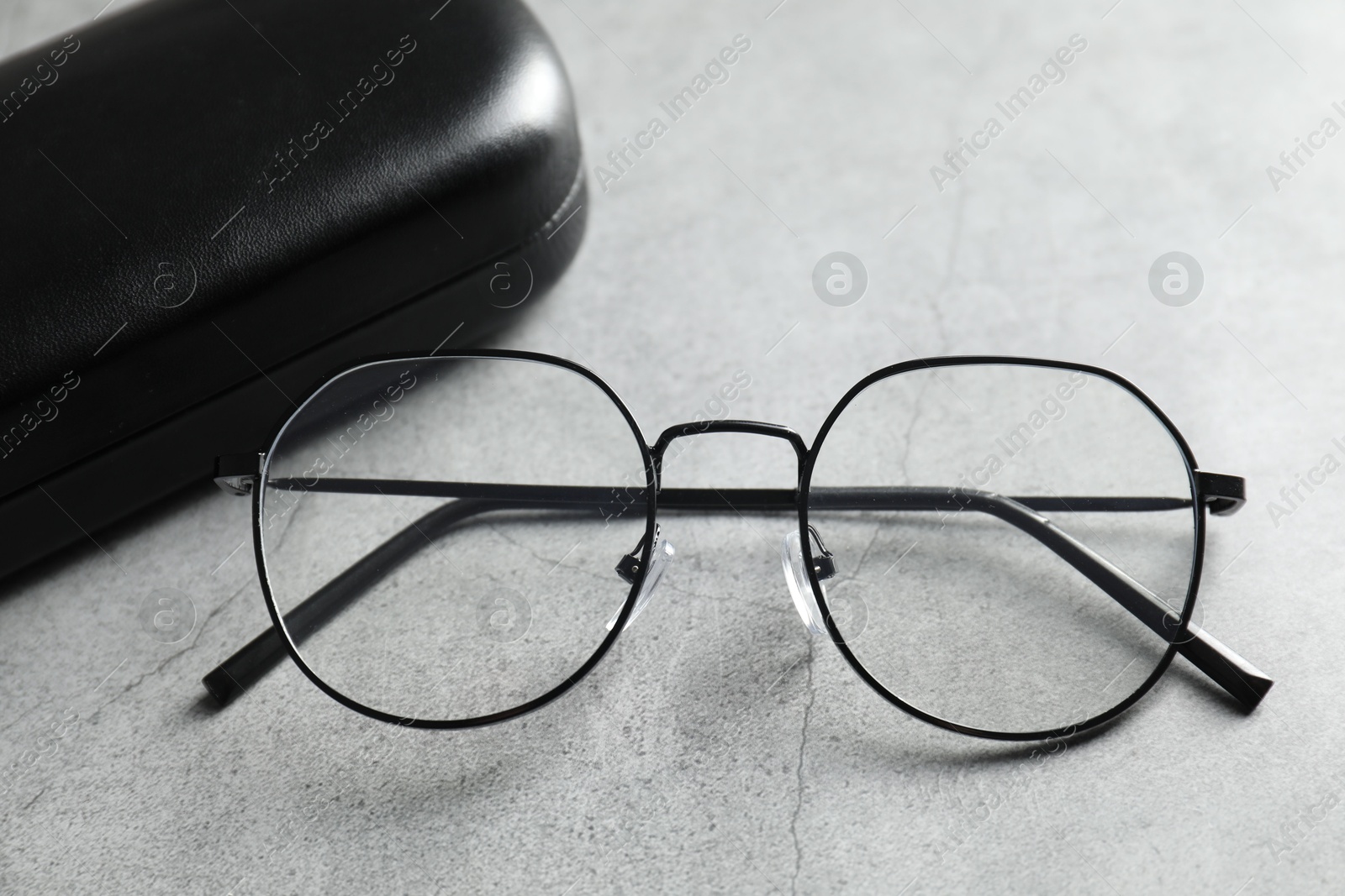 Case with stylish glasses on grey table, closeup Photo of Case with stylish glasses on grey table, closeup