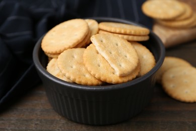 Photo of Tasty salty crackers on wooden table, closeup