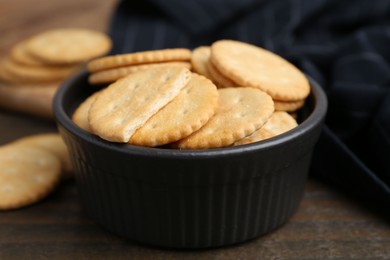 Photo of Tasty salty crackers on wooden table, closeup
