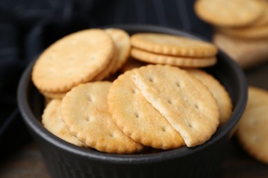 Photo of Tasty salty crackers on wooden table, closeup