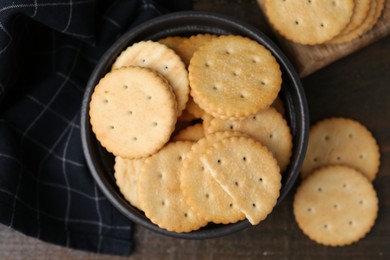 Photo of Tasty salty crackers on wooden table, flat lay