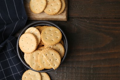 Photo of Tasty salty crackers on wooden table, flat lay. Space for text