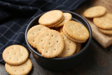 Photo of Tasty salty crackers on wooden table, closeup