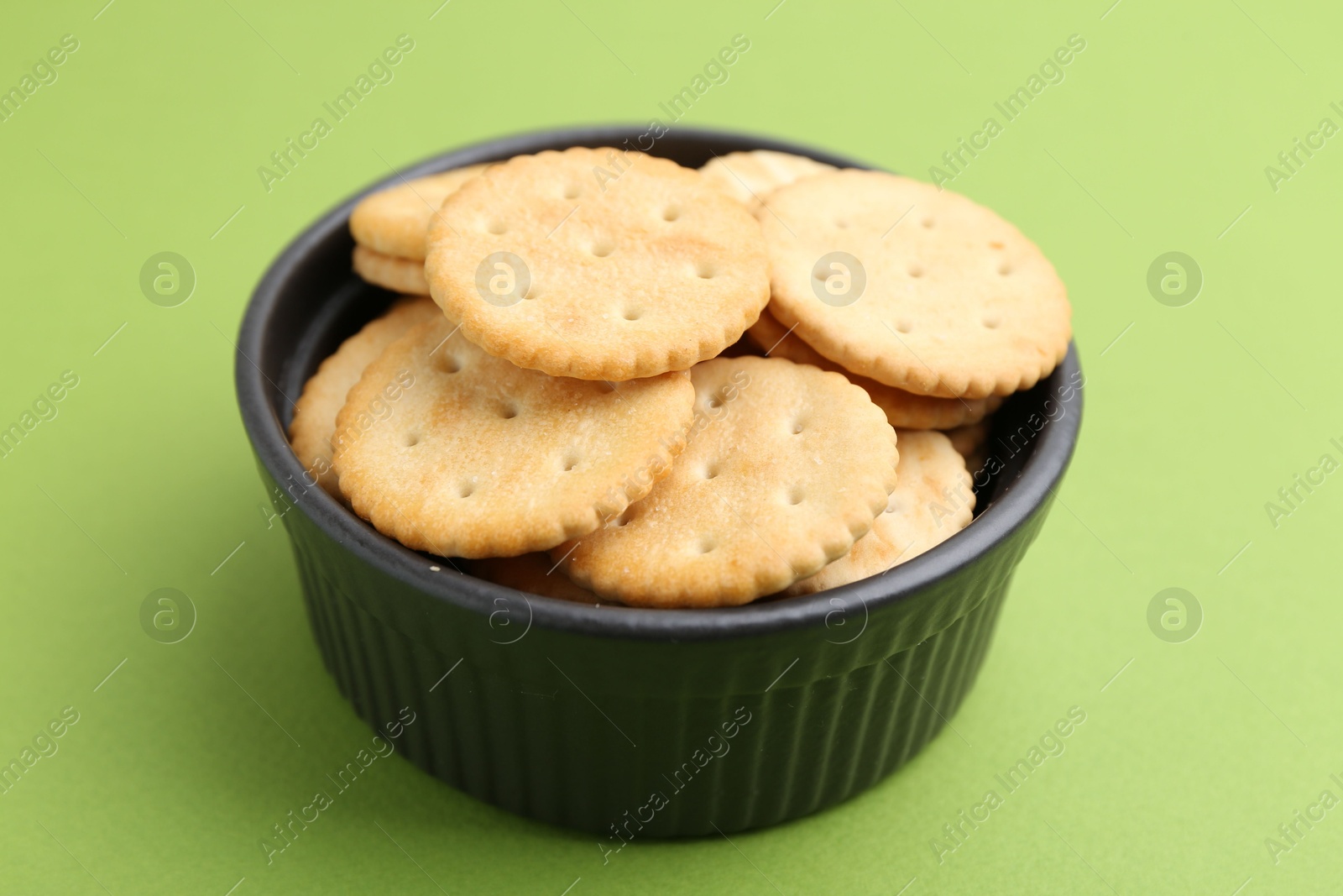Tasty salty crackers on green background, closeup Photo of Tasty salty crackers on green background, closeup