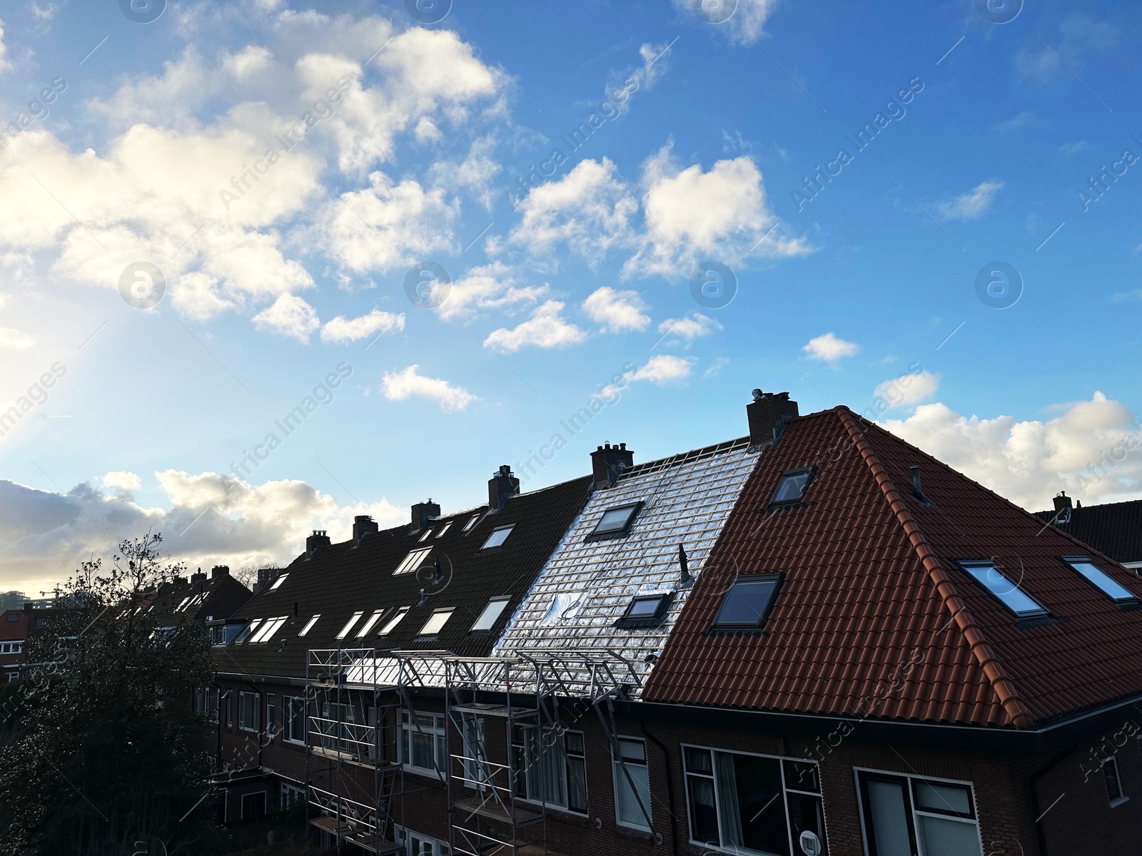 Residential building with roof renovation under blue sky Photo of Residential building with roof renovation under blue sky