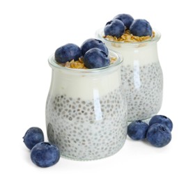 Photo of Delicious pudding with chia seeds, yogurt, blueberries and granola in glasses isolated on white. Superfood