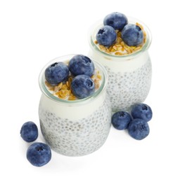Photo of Delicious pudding with chia seeds, yogurt, blueberries and granola in glasses isolated on white. Superfood