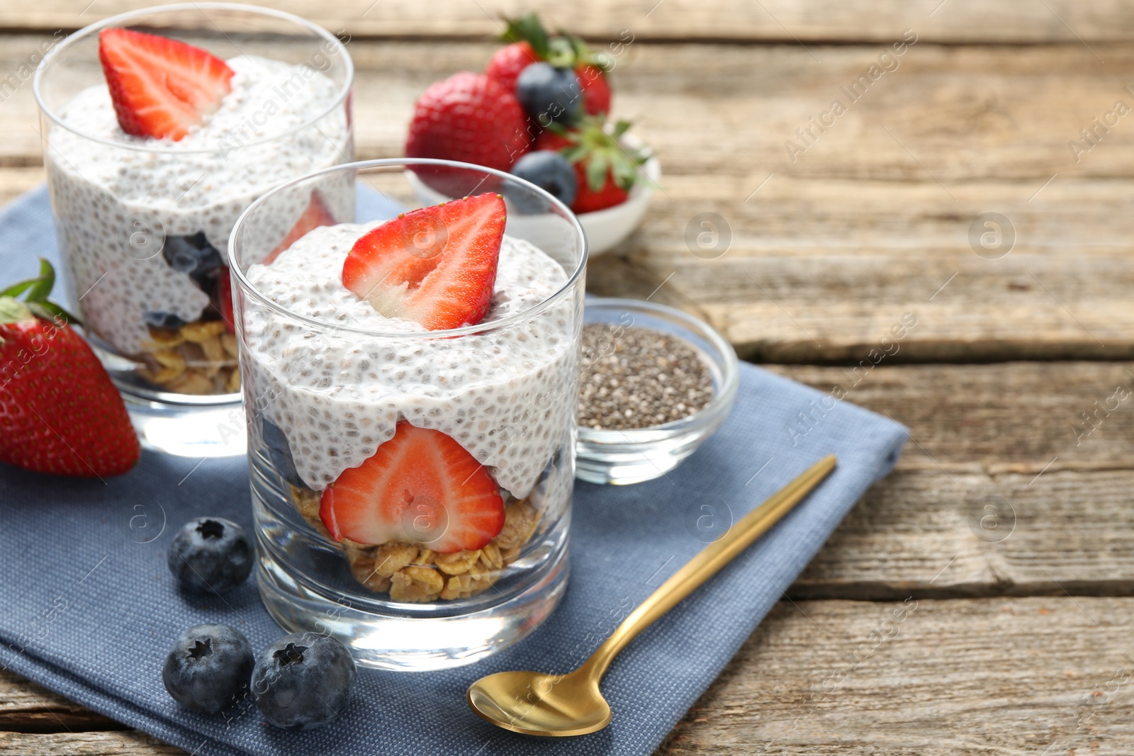 Delicious dessert with chia seeds, yogurt, granola, strawberries and blueberries on wooden table, closeup with space for text. Superfood Photo of Delicious dessert with chia seeds, yogurt, granola, strawberries and blueberries on wooden table, closeup with space for text. Superfood