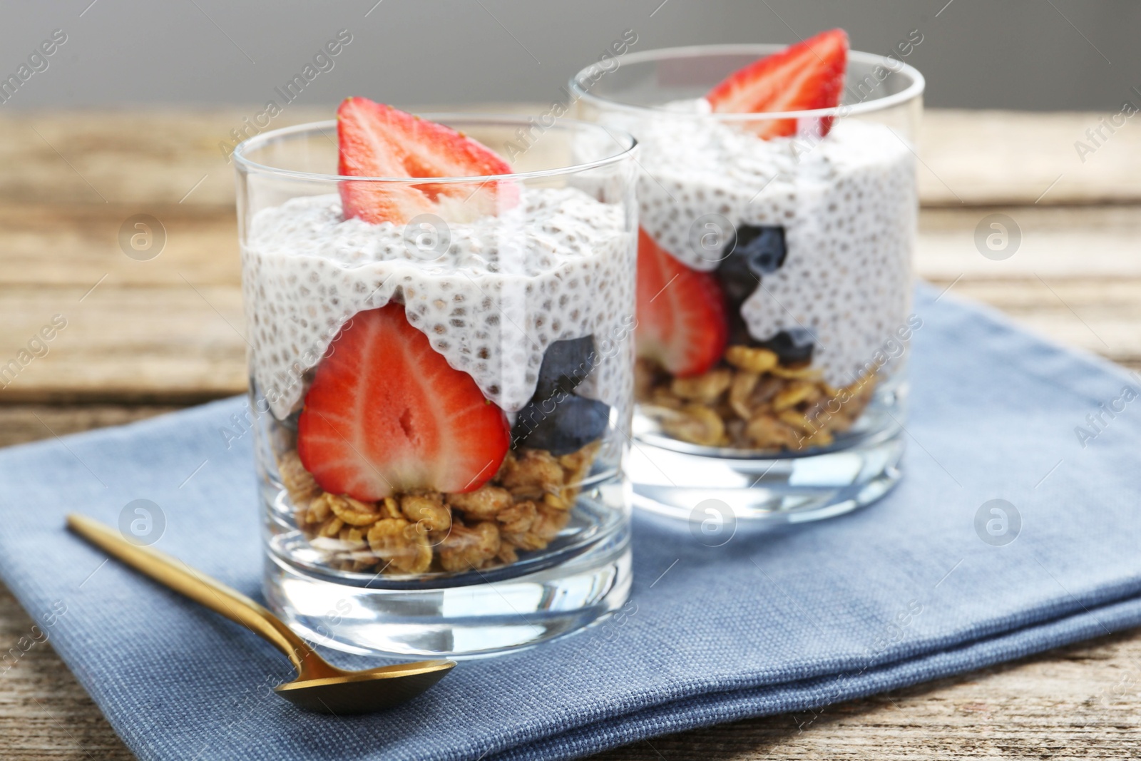 Delicious dessert with chia seeds, yogurt, granola, strawberries and blueberries on wooden table, closeup. Superfood Photo of Delicious dessert with chia seeds, yogurt, granola, strawberries and blueberries on wooden table, closeup. Superfood