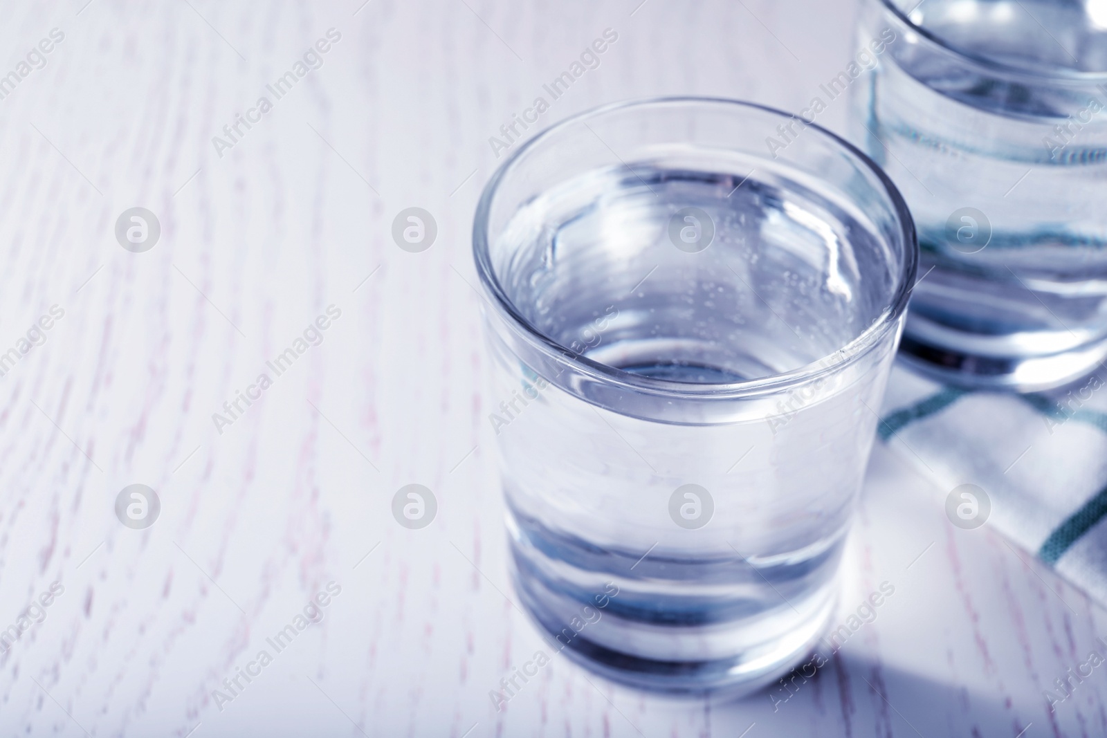 Glass of soda water on white wooden table. Space for text Image of Glass of soda water on white wooden table. Space for text