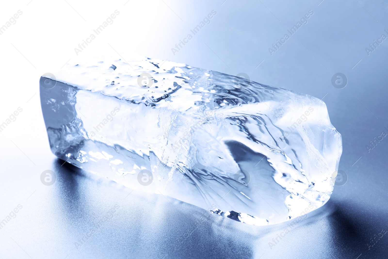 Piece of clear ice on light blue table Image of Piece of clear ice on light blue table