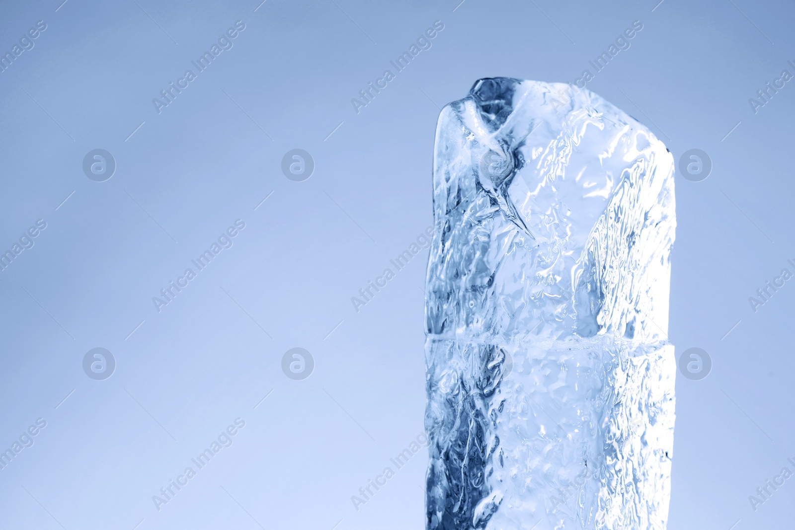 Piece of clear ice on light blue background. Space for text Image of Piece of clear ice on light blue background. Space for text