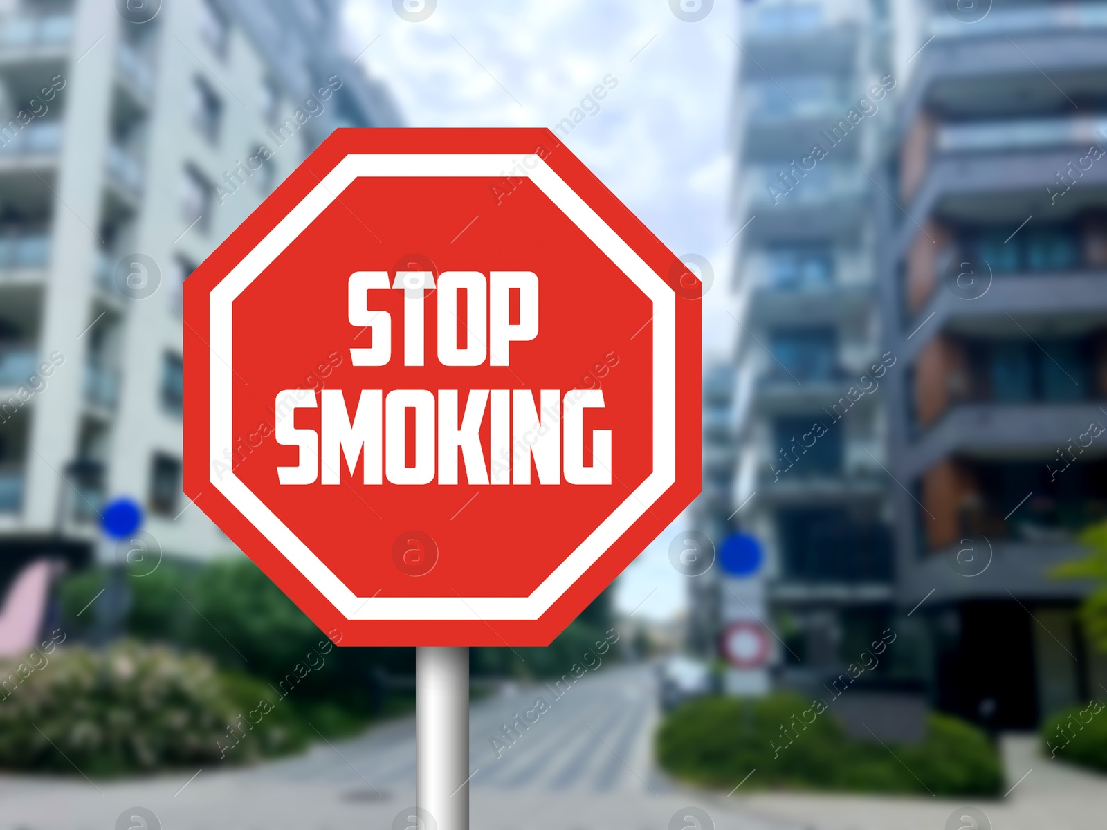 Stop Smoking sign on city street with buildings Image of Stop Smoking sign on city street with buildings