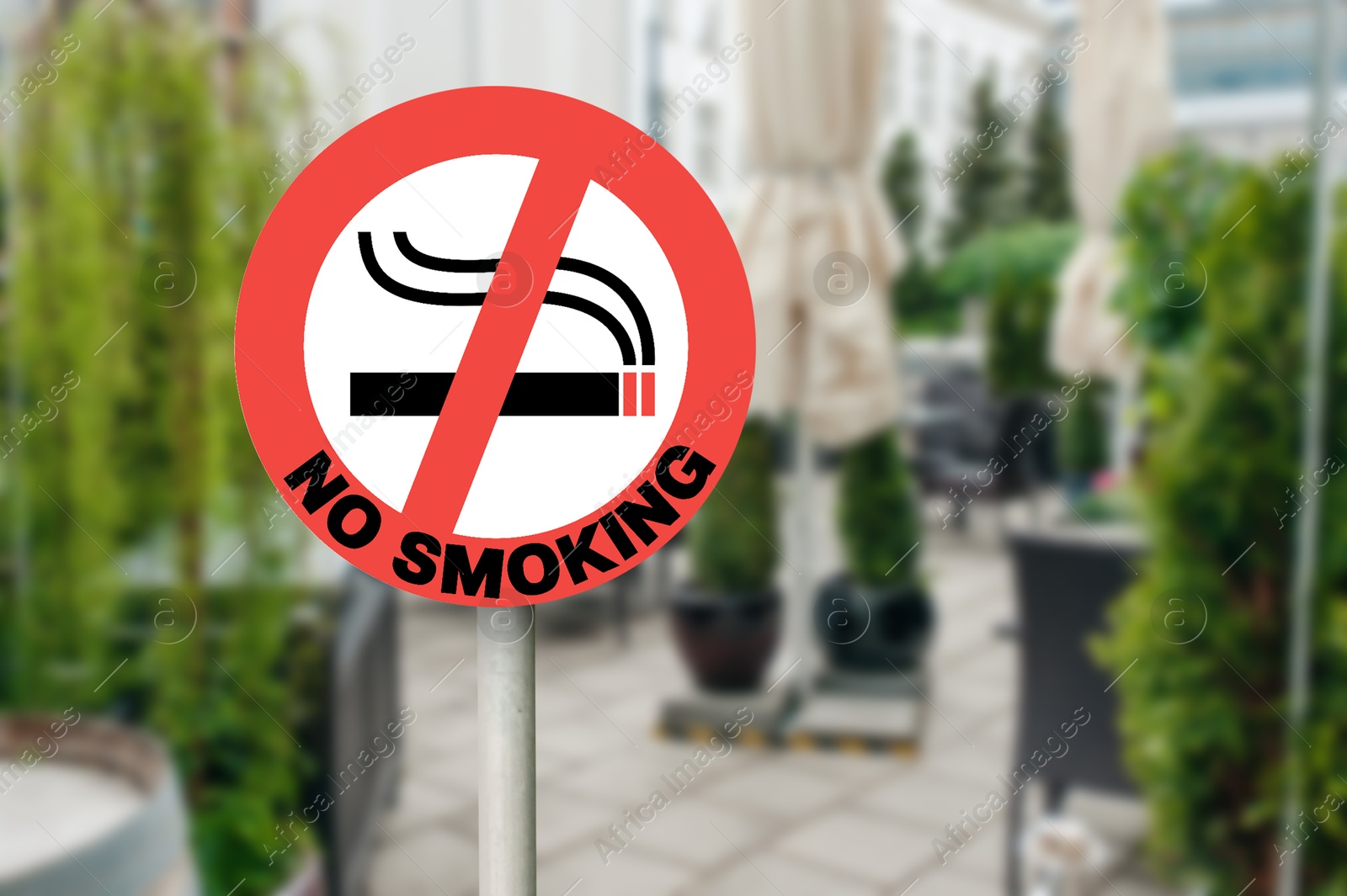 No Smoking sign near outdoor cafe on city street. Space for text Image of No Smoking sign near outdoor cafe on city street. Space for text