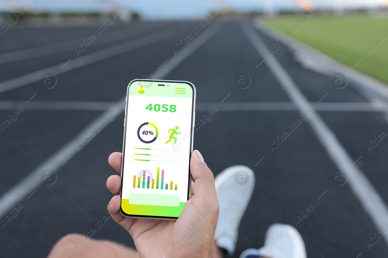 Man using step counting app on smartphone at stadium, closeup Image of Man using step counting app on smartphone at stadium, closeup