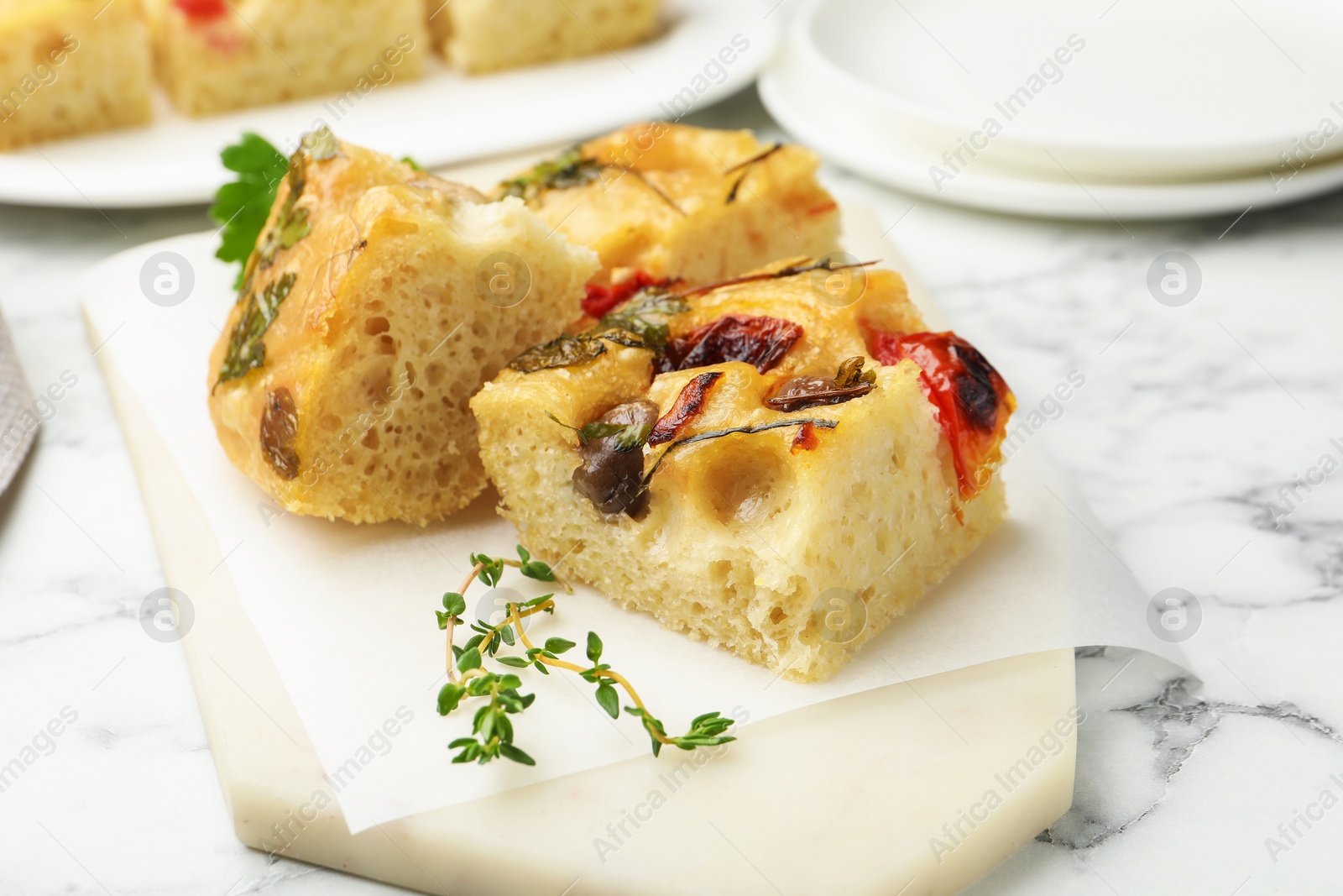 Pieces of delicious focaccia on white marble table, closeup Photo of Pieces of delicious focaccia on white marble table, closeup