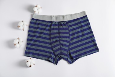 Photo of Comfortable men's underwear and cotton flowers on white background, flat lay