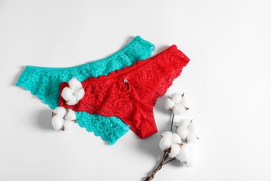 Photo of Women's underwear. Beautiful panties and cotton flowers on white background, flat lay