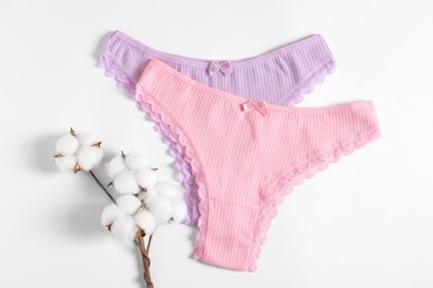 Photo of Women's underwear. Beautiful panties and cotton flowers on white background, flat lay