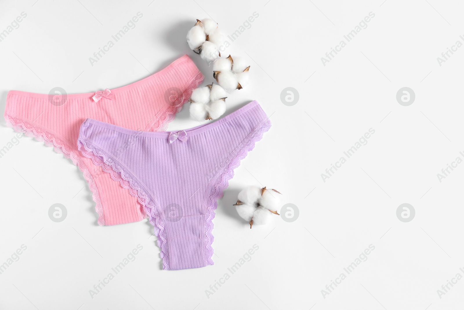 Women's underwear. Beautiful panties and cotton flowers on white background, flat lay. Space for text Photo of Women's underwear. Beautiful panties and cotton flowers on white background, flat lay. Space for text