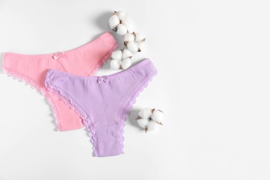 Photo of Women's underwear. Beautiful panties and cotton flowers on white background, flat lay. Space for text