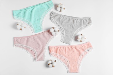 Photo of Women's underwear. Beautiful panties and cotton flowers on white background, flat lay