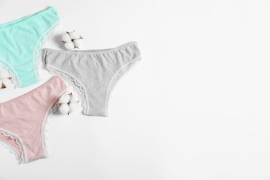 Photo of Women's underwear. Beautiful panties and cotton flowers on white background, flat lay. Space for text