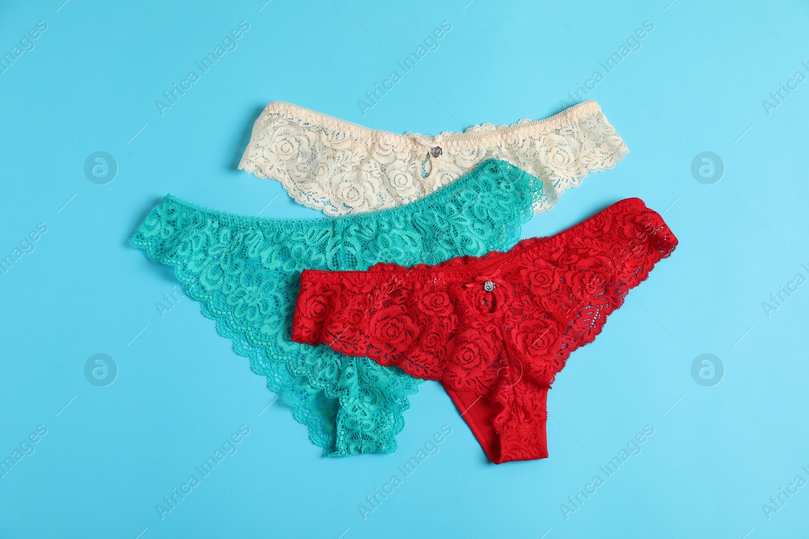 Women's underwear. Beautiful panties on light blue background, flat lay Photo of Women's underwear. Beautiful panties on light blue background, flat lay