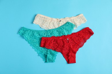 Photo of Women's underwear. Beautiful panties on light blue background, flat lay