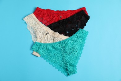 Photo of Women's underwear. Beautiful panties on light blue background, flat lay