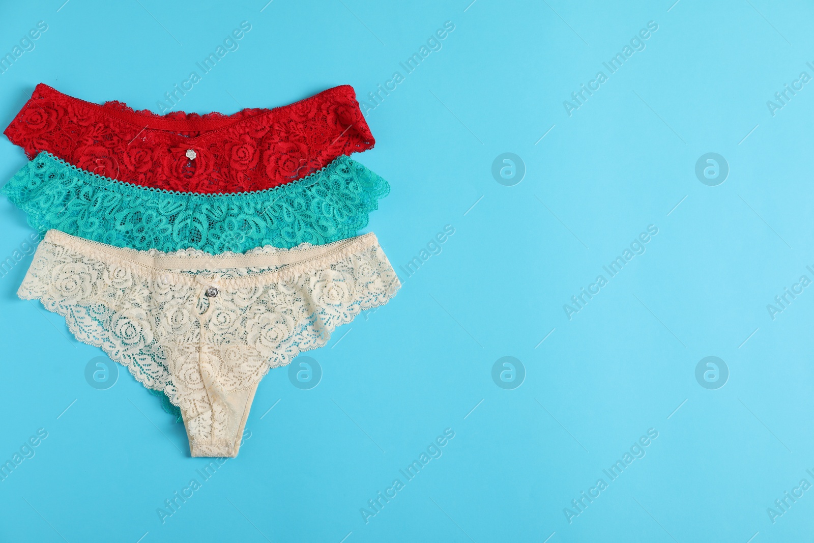 Women's underwear. Beautiful panties on light blue background, flat lay. Space for text Photo of Women's underwear. Beautiful panties on light blue background, flat lay. Space for text
