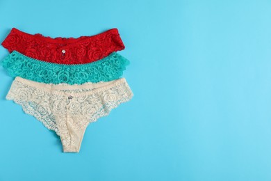 Photo of Women's underwear. Beautiful panties on light blue background, flat lay. Space for text