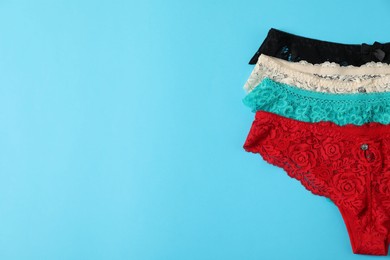 Photo of Women's underwear. Beautiful panties on light blue background, flat lay. Space for text