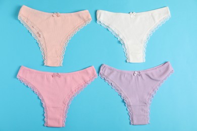 Photo of Women's underwear. Beautiful panties on light blue background, flat lay