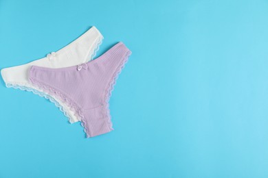 Photo of Women's underwear. Beautiful panties on light blue background, flat lay. Space for text