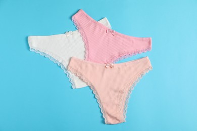 Photo of Women's underwear. Beautiful panties on light blue background, flat lay