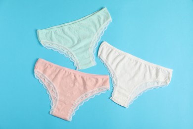 Photo of Women's underwear. Beautiful panties on light blue background, flat lay