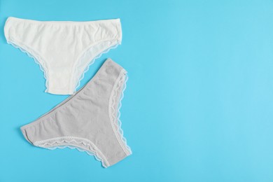 Photo of Women's underwear. Beautiful panties on light blue background, flat lay. Space for text
