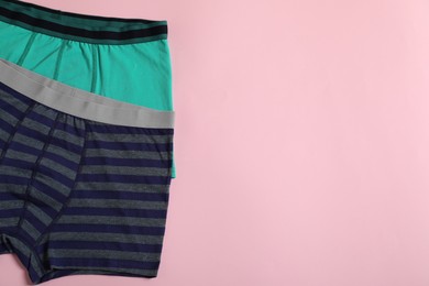 Photo of Comfortable men's underwear on pink background, flat lay. Space for text