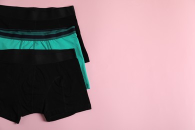 Photo of Comfortable men's underwear on pink background, flat lay. Space for text