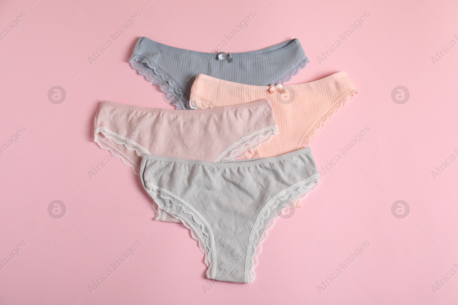 Women's underwear. Beautiful panties on pink background, flat lay Photo of Women's underwear. Beautiful panties on pink background, flat lay