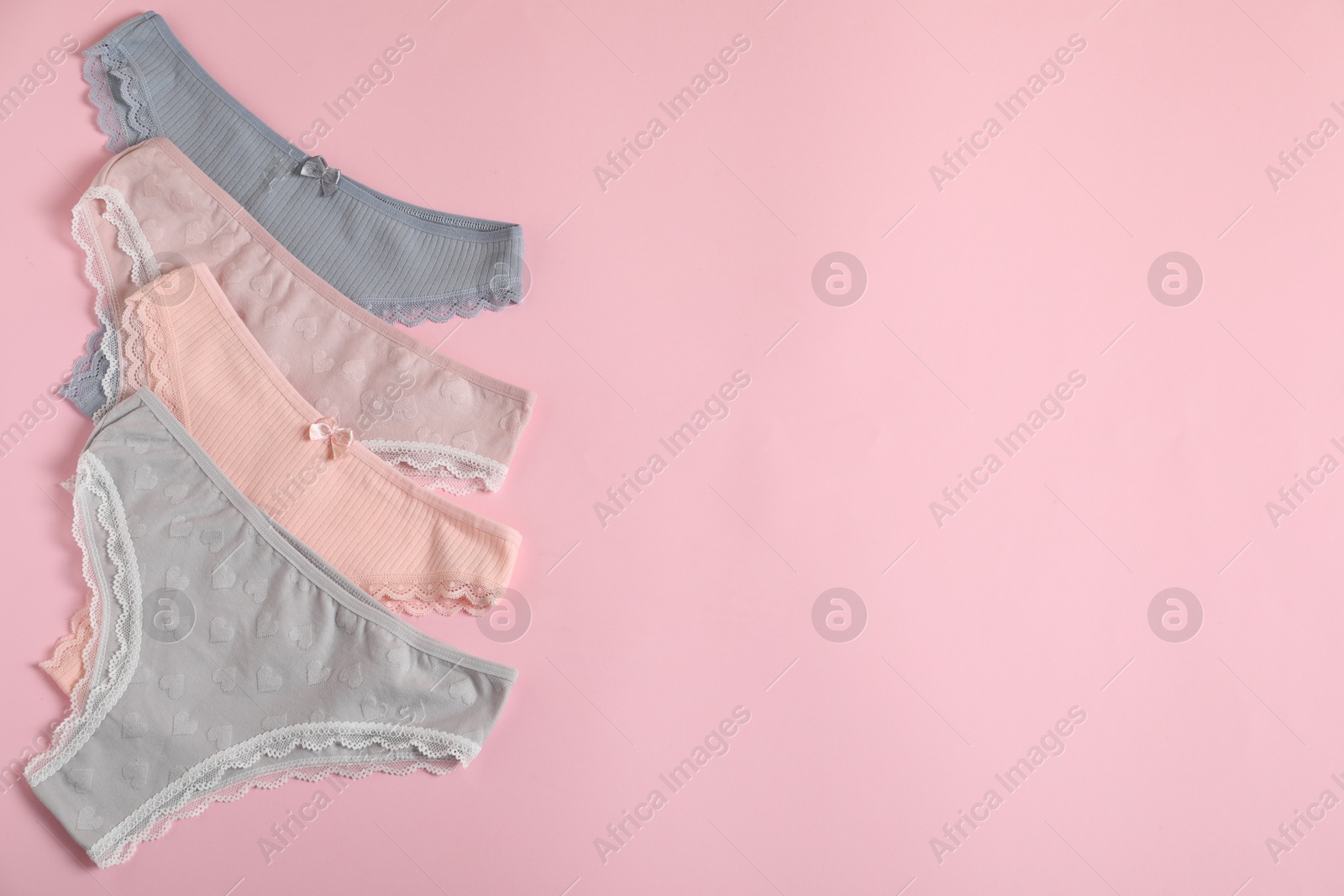 Women's underwear. Beautiful panties on pink background, flat lay. Space for text Photo of Women's underwear. Beautiful panties on pink background, flat lay. Space for text