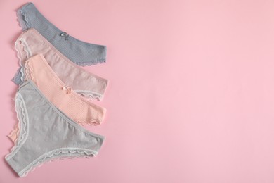 Photo of Women's underwear. Beautiful panties on pink background, flat lay. Space for text