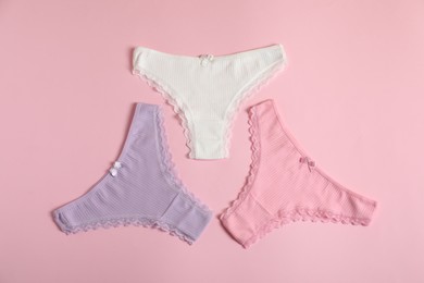 Photo of Women's underwear. Beautiful panties on pink background, flat lay
