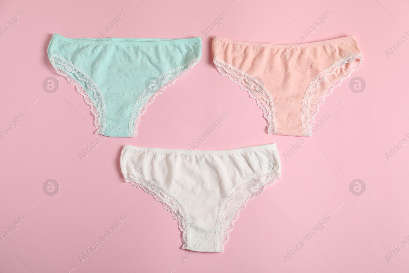 Women's underwear. Beautiful panties on pink background, flat lay Photo of Women's underwear. Beautiful panties on pink background, flat lay